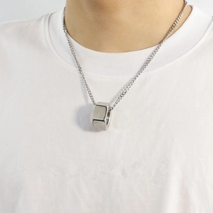 Close-up of a silver industrial hex nut pendant necklace worn by a male model