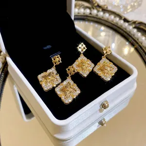 Élégantes boucles d'oreilles fleurs plaquées or avec zircons et métal brossé vintage