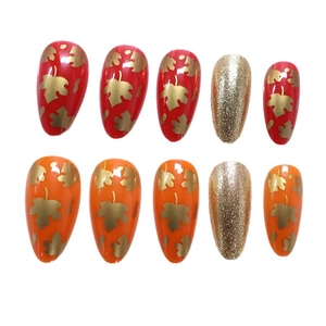 Almond press-on nails with autumn maple leaf designs and gold glitter finish