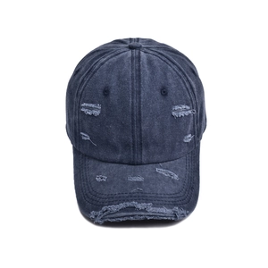 Close-up of distressed denim baseball cap with vintage frayed holes and washed texture