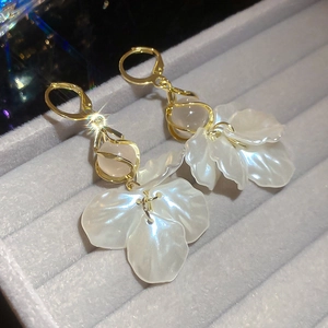 Detail of elegant gold lever-back earrings with pearl petals and pink opal bead