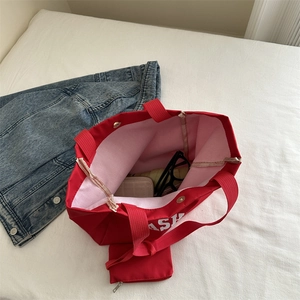 Large red Oxford cloth tote bag with ASH print and matching zipper pouch on white bedding