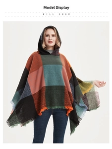 Close-up of multicolored plaid hooded poncho cape featuring soft fabric and fringe tassels