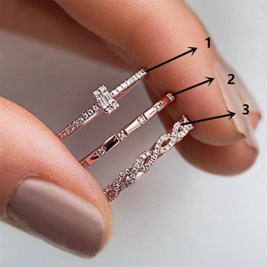 Detailed close-up of rose gold zircon stacked rings in three elegant creative designs