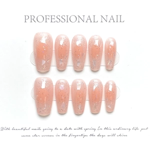 Détails de faux ongles faits main avec dégradé rose-orangé, paillettes et éclats de nacre