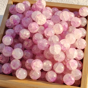 Detailed view of purple and white marble texture glass beads in a wooden tray