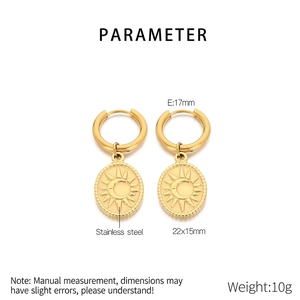 Detail view of gold stainless steel oval earrings with sun and moon engravings