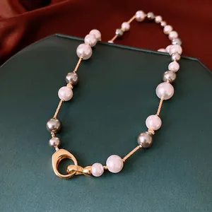 Collier de perles vintage français avec boucle fer à cheval dorée sur fond de soie