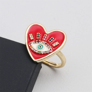 Macro detail of red heart evil eye ring with cubic zirconia and gold finish