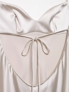 Detail of champagne satin dress showing back ribbon bow and smooth silk texture