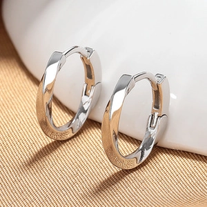 Macro shot of silver twisted metal hoop earrings with high-polish finish and detail