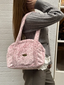 Detail der pinkfarbenen Leoparden-Plüschtextur und Metallplakette an der Tasche