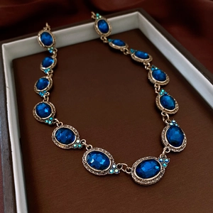 Détail macro d'un collier vintage avec pierre bleue ovale dans son écrin à bijoux
