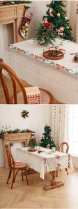 Detailed cream Christmas tablecloth featuring festive lace embroidery of holly leaves and berries
