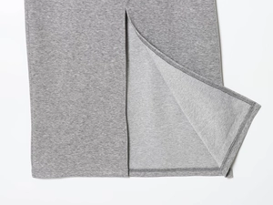 Detail view of the knit skirt hem featuring a split design and grey marl textured fabric