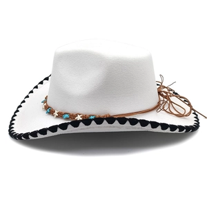 Close-up of white felt cowboy hat featuring black wavy edge and starfish woven band