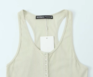 Macro detail of sage green ribbed cotton top with four buttons and brand neck label