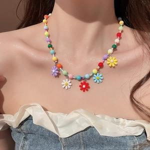 Close-up of vibrant beaded floral necklace worn on neck with colorful flower charms