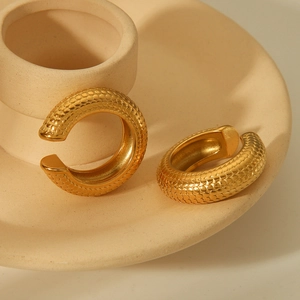 Golden stainless steel C-shape hoop earrings featuring a vintage scale texture design