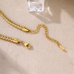 Macro view of gold stainless steel wheat chain with lobster clasp and extension link