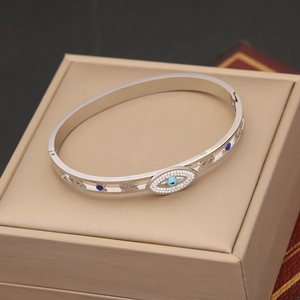 Silver evil eye open cuff bracelet with blue gemstone and sparkling crystals on jewelry box