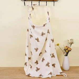 Detail of white cotton nursing cover with brown bear patterns and wooden ring