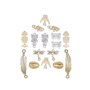 Detailed macro view of assorted vintage alloy pendants including swallow and fishbone charms