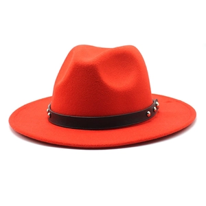 Close-up of red wool fedora with a black leather band and silver metal rivet accents