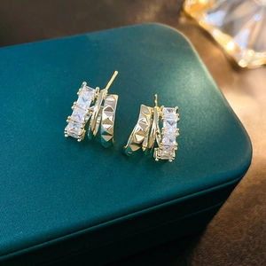 Elegant gold plated C-shaped geometric earrings with sparkling zircons and pyramid texture
