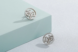 Detail of silver hollow butterfly earrings with rhinestones on light blue geometric base
