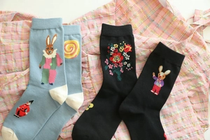 Detail view of cotton socks with rabbit illustrations and floral embroidery in blue and black