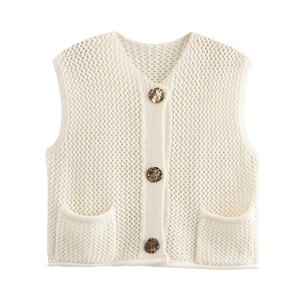 Detailed close-up of cream chunky knit vest featuring marble buttons and patch pockets