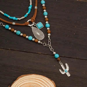 Detail of vintage bohemian necklace set featuring turquoise beads and cactus charm