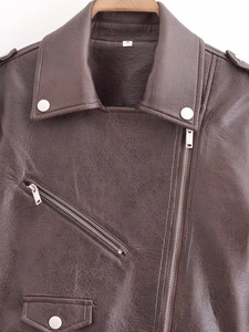 Detail of dark brown PU leather jacket featuring side zipper and silver metal hardware