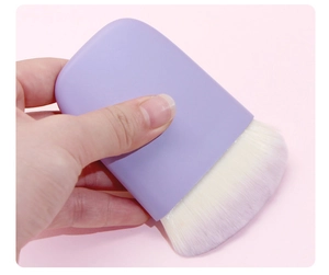 Flat purple silicone handle blush brush with soft white synthetic bristles detail