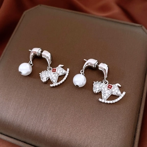Gros plan de boucles d'oreilles cheval en argent avec perles et cristaux brillants