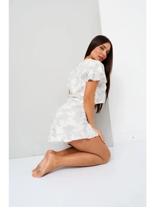 Dettaglio del set loungewear con stampa marmorizzata, pantaloncini a balze e top