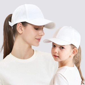 Matching set of white parent-child baseball caps worn by models in a minimalist style