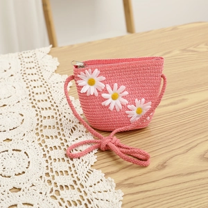 Detail of pink woven straw bag for girls with 3D white daisy flowers and rope strap