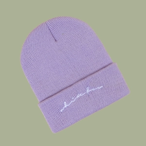 Detail of light purple ribbed knit beanie featuring white fox cursive embroidery