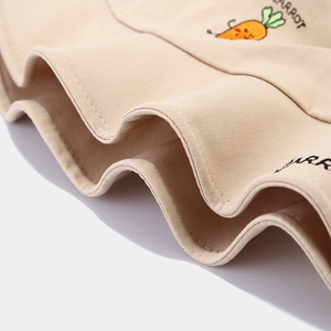 Close-up of carrot embroidery and CARROT text on a beige cotton bucket hat detail