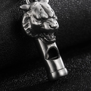 Detailed view of vintage lion head whistle pendant in antique silver finish on black back