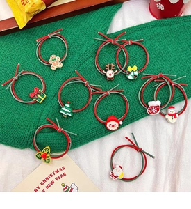 Detail of Christmas hair ties featuring resin charms like Santa, reindeer, and snowflakes
