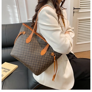 Deep brown geometric print tote bag shown being worn over the shoulder with a white suit