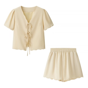 Detailed view of cream-colored two-piece set with tie-up top and high-waisted shorts