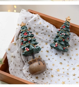 Close-up of resin mini Christmas tree with gold star, red bows and candy canes