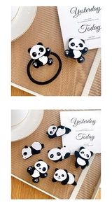 Detailed view of cute panda hair clips and elastic hair tie on a decorative tray