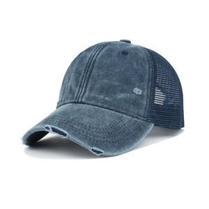 Detailed close-up of distressed navy blue washed cotton fabric and breathable mesh cap