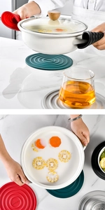 Detailed view of heat-resistant silicone mats and pot handle covers on marble surface