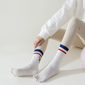 Detail of white five-toe yoga socks with blue-red stripes and non-slip silicone grip